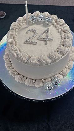 a white cake with the number twenty four on it sitting on top of a table