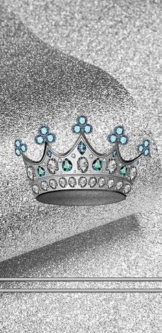 a silver crown with blue and green jewels on it's head is shown in this black and white photo