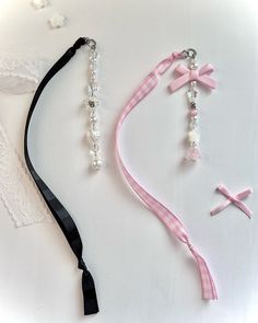 two necklaces, one with a pink ribbon and the other with a cross on it