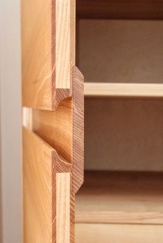 a close up view of the bottom part of a wooden cabinet with two open shelves