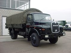 an army truck parked in front of a building