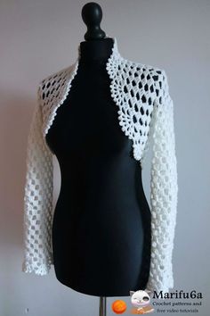 a black mannequin with a white crochet jacket on it's back