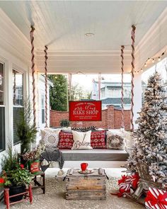 a porch decorated for christmas with red and white decorations