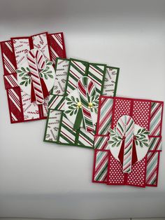 four christmas cards on a white surface with red, green and white paper in the middle