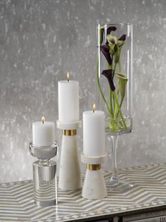 candles and vases with flowers in them on a table