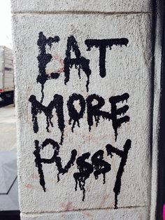 graffiti on the side of a building that says eat more plasty written in black ink