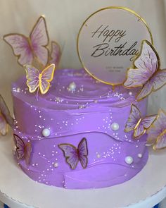 there is a purple cake with butterflies on it