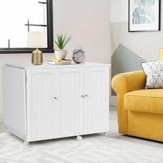 a living room with a yellow couch and white cabinet