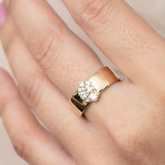 A sweet diamond cluster. DETAILS Metal - 14k yellow gold Diamond(s) - 0.38tcw GH/SI2 round brilliant cut Band width - 6.78mm WHY WE LOVE IT As part of our new gender neutral Engagement Ring Collection - the Skylar Ring is made up of a dainty 0.38tcw cluster of round cut diamonds, all four-prong set, centered atop a thick polished 14k gold band. The sweet cluster of diamonds with a thick band is a pair we love to see. This ring is perfect for those who want that diamond ring to be less in the lim