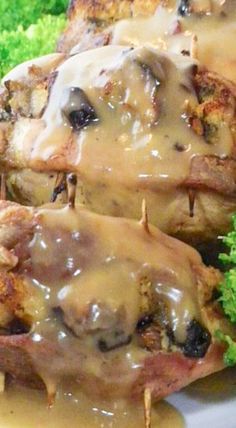 three pieces of meat covered in gravy and broccoli