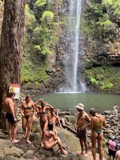 some people are standing near a waterfall