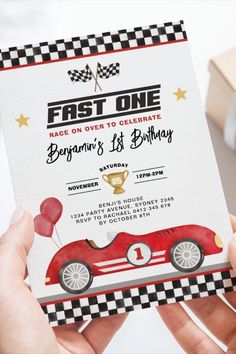 a person holding up a birthday card with a race car on it