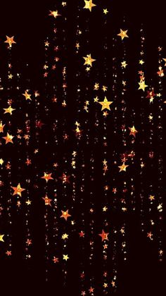 gold stars are falling down from the dark sky, creating a background for an image