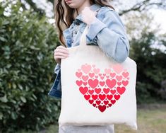 a woman holding a bag with hearts on it