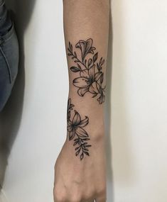 a woman's arm with a flower tattoo on the left side of her wrist