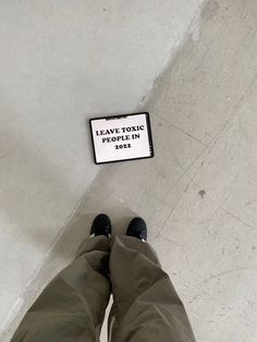 a person standing in front of a sign on the ground with their feet up and legs down