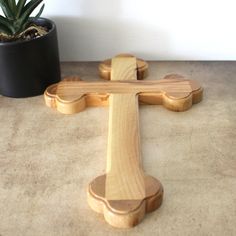 a wooden cross sitting next to a potted plant