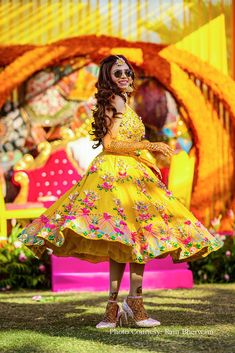 a woman in a yellow dress standing on the grass