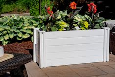 a white planter filled with flowers sitting on top of a patio