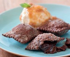 three desserts on a blue plate with ice cream