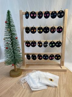 a christmas tree and some ornaments on a wooden stand with a white bag next to it