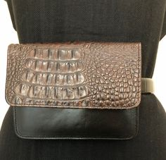 "Brahmin mini crossbody, shoulder, or 'on a belt' bag. The bag measures 6\" wide 4.5\" high and the strap drop is 23.5\". The bag is a combination of smooth black leather and Brahmin's signature croc embossed brown leather. It is stamped in an oval on the inside flap \"Brahmin, the image of a ship, Fairhaven, Massachusetts U.S.A.\"  There are two slots under the flap in the front, one zippered compartment on the inside and one slot across the back above the 3\" belt opening. The black leather is in excellent condition with only the small imperfections that one normally sees in real leather. This vintage Brahmin bag has had only very light wear. The only real sign of wear is on the lower left corner. Please see the picture.   Brahmin bags are low-key luxury bags that are gems. The company h Formal Brown Bag With Removable Belt, Formal Black Crossbody Belt Bag, Classic Brown Bag With Belt Detail, Classic Brown Belted Bag, Classic Brown Shoulder Bag With Removable Belt, Brown Rectangular Shoulder Bag With Removable Belt, Formal Black Belt Bag With Removable Belt, Classic Crossbody Belt Bag With Cell Phone Pocket, Formal Brown Belt Bag