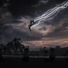 a man flying through the air while riding a skateboard in front of a lightning storm