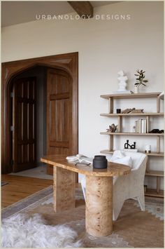 a wooden table sitting in the middle of a living room next to a book shelf