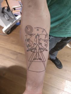 a man with a tattoo on his arm that has an image of a plane in the sky