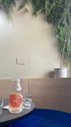 a grapefruit is sitting on a table with two glasses