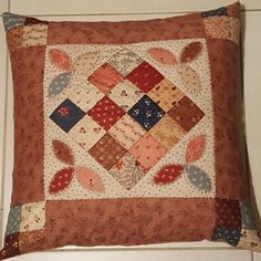 a close up of a decorative pillow on the floor with white tiles in the background