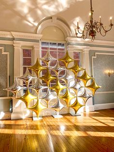 a room with a chandelier hanging from the ceiling next to a wooden floor