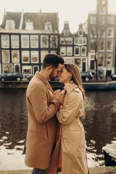 a man and woman standing next to each other near water