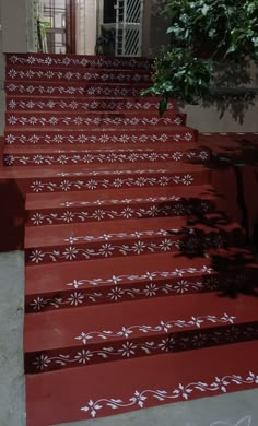 the steps are painted red and white with designs on them, as well as a potted plant