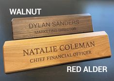 three wooden name plaques on top of a table with the names of two different companies