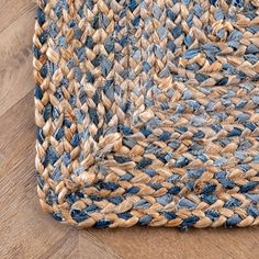 a blue and beige area rug on top of a wooden floor