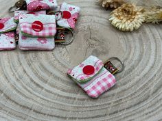 several small pink and white purses sitting on top of a wooden table next to flowers