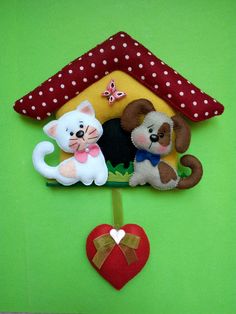 two stuffed animals sitting on top of a house shaped like a cat, dog and puppy