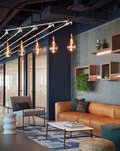 a living room filled with furniture and hanging lights