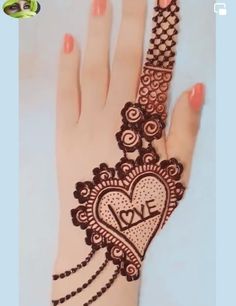 a henna tattoo on someone's hand with the word love written on it