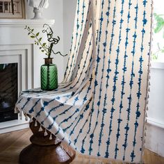 a white and blue curtain hanging in front of a fireplace