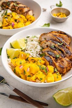 two bowls filled with chicken, rice and pineapple salsa next to lime wedges