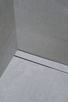 the corner of a shower stall is shown with no door and only one piece of tile