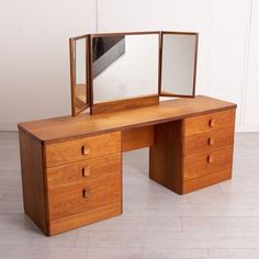 a wooden desk with mirror and drawers on it