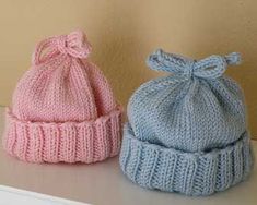 two knitted hats sitting on top of a table