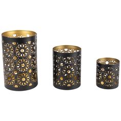 three black and gold candle holders with holes in them, one has an intricate design on it