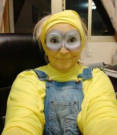 a woman with painted face and overalls sitting in front of a window