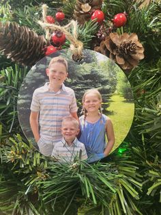 an ornament hanging from a christmas tree with two children