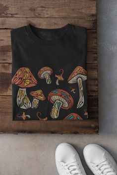 Cottagecore Mushroom T-shirt Printed on a super soft, cotton tee Dispatched in 5 working days or sooner Unisex Free UK delivery Material: 100% ringspun cotton. Chest (to fit): S  34/36   M  38   L  40/42   XL  44/46   XXL  48/50 ECO-FRIENDLY Each garment is made to order, reducing extra material and energy that would be otherwise wasted We use DTG printing process which is easier on the environment than screen-printing Our ink is bright and also eco-friendly. Do not tumble dry. Wash at 30 degree Halloween Fairy Grunge Tops, Goblincore Crew Neck T-shirt For Fall, Black Fairy Grunge Cotton T-shirt, Black Fairycore Crew Neck Top, Black Crew Neck T-shirt With Mushroom Print, Black Goblincore Top With Graphic Print, Fairy Grunge Black T-shirt For Halloween, Mushroom Clothes, Fairy Grunge Clothes