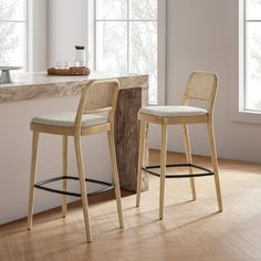 two stools sitting next to each other in front of a counter top and window